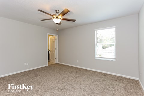 the master bedroom has a ceiling fan and carpeted flooring