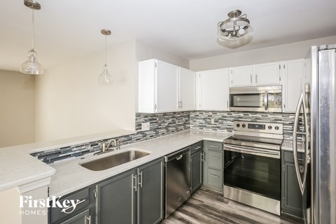 A kitchen with a stove top oven and a refrigerator.