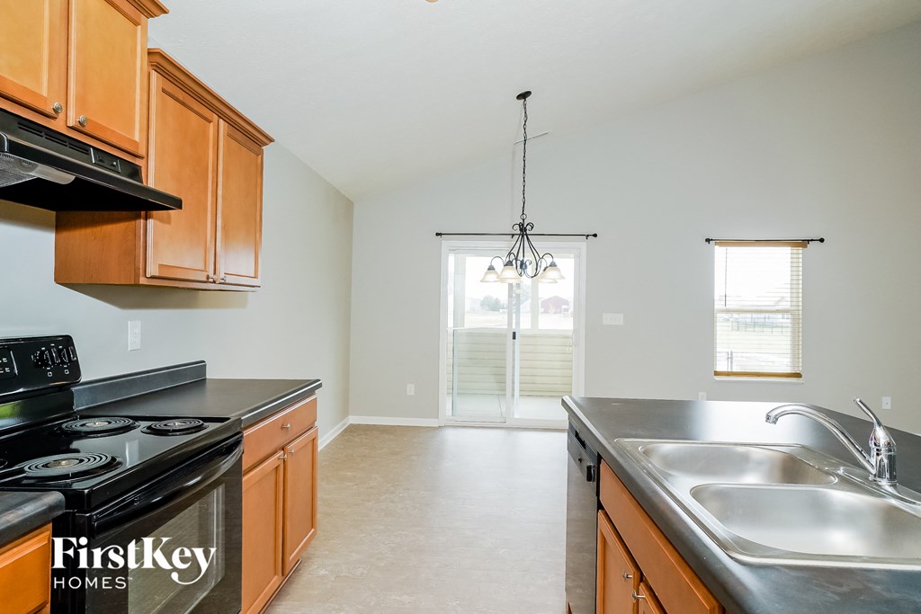 A kitchen with wooden cabinets and a black stove top oven.