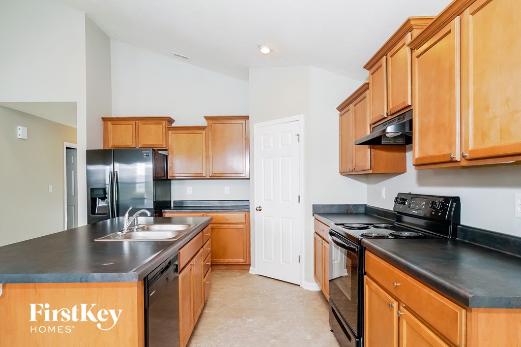 A kitchen with wooden cabinets and a black countertop.