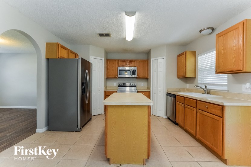 a kitchen with wooden cabinets and a stainless steel refrigerator