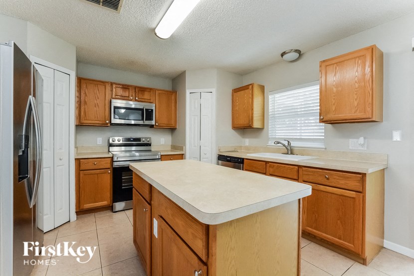 a kitchen with wooden cabinets and a white counter top
