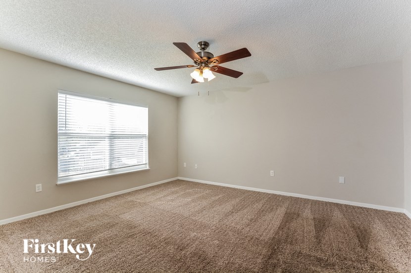 a living room with a ceiling fan and a window