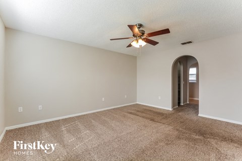 a living room with carpet and a ceiling fan