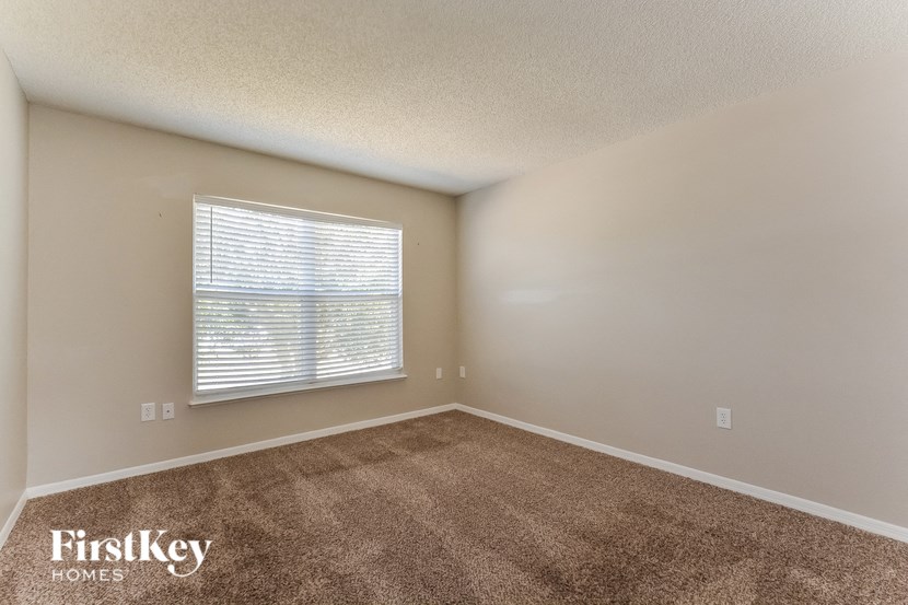 the living room of a home with carpet and a window