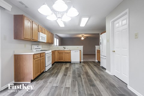 A kitchen with wooden cabinets and a white door.