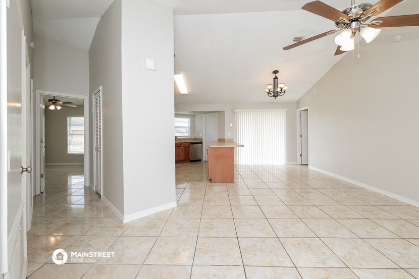 an empty kitchen and living room with a ceiling fan