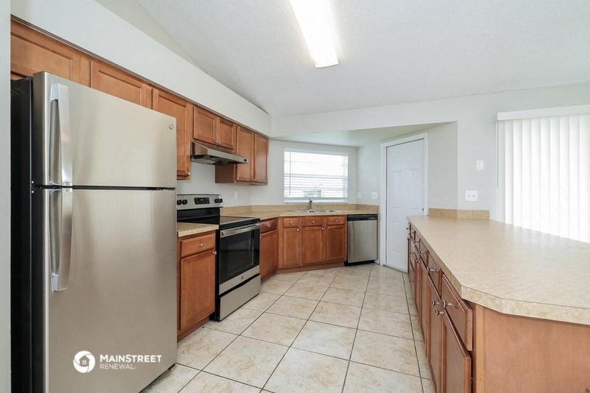 a kitchen with wooden cabinets and stainless steel appliances