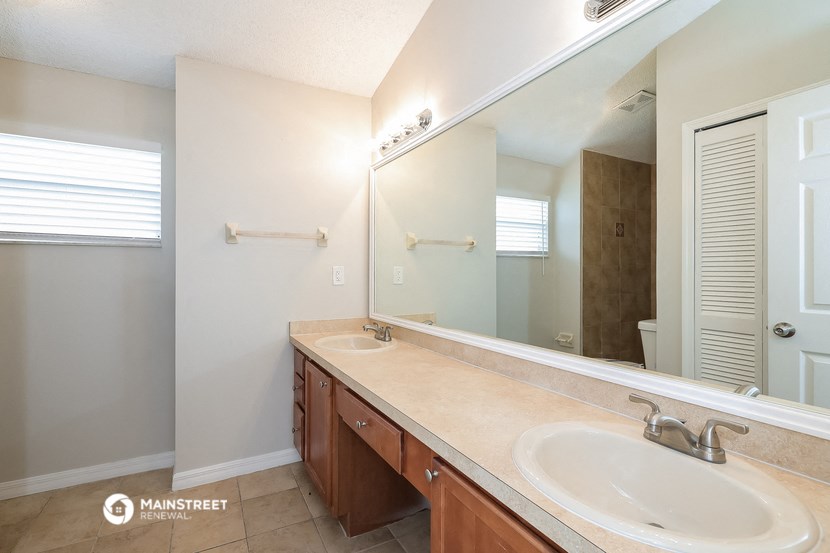 a bathroom with two sinks and a large mirror