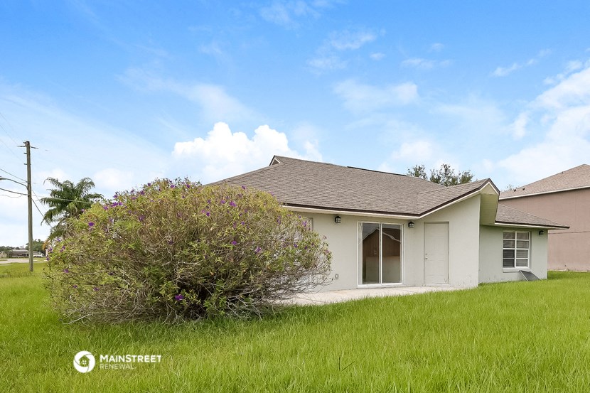 a small white house with a tree in front of it