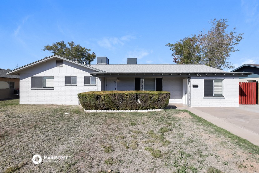 a white house with a yard and a red garage door