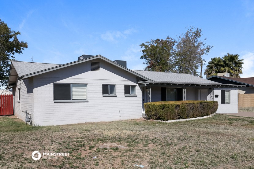 a white house with a gray roof and a yard