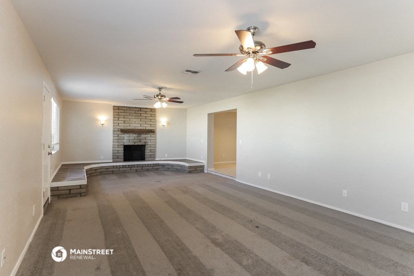 the living room with fireplace and ceiling fan