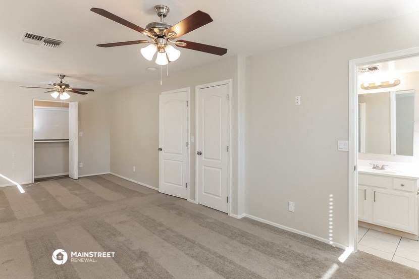 an empty living room with a ceiling fan
