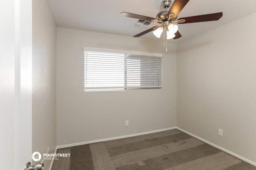 a bedroom with a ceiling fan and a window