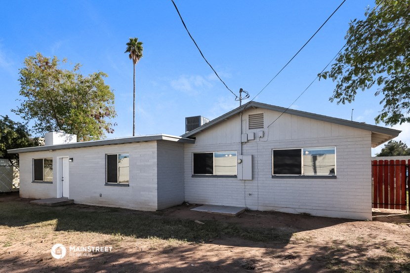 a small white house with a palm tree behind it