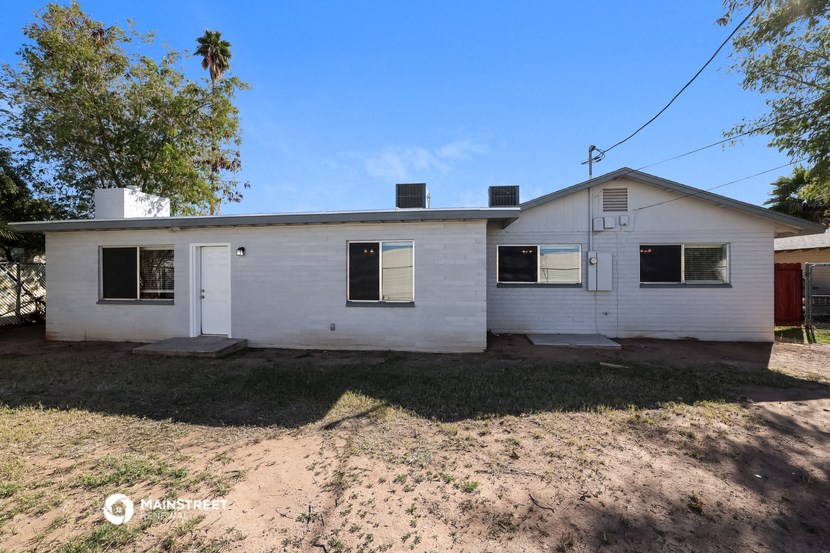 a small white house with a dirt road in front of it