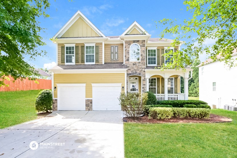 a house with a white garage door in front of a lawn