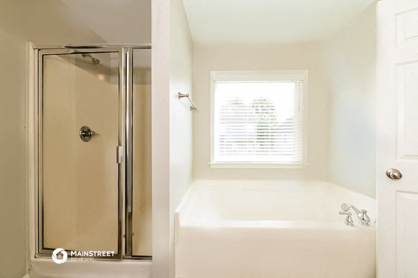 a bathroom with a shower and a tub and a window