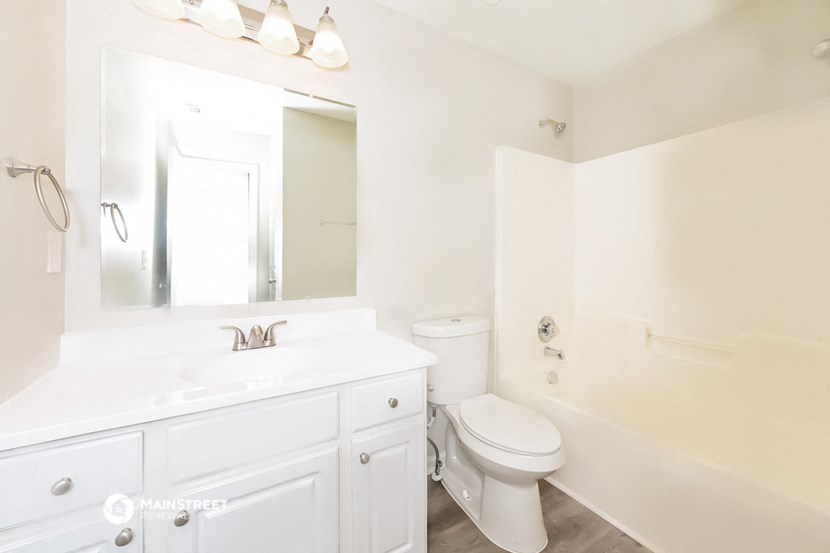 a bathroom with a sink toilet and a mirror