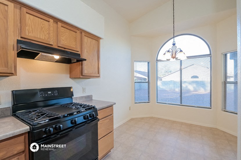 an empty kitchen with a stove and a window