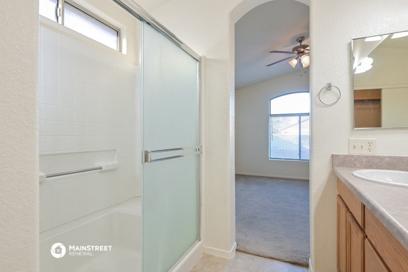a bathroom with a shower and a sink and a mirror