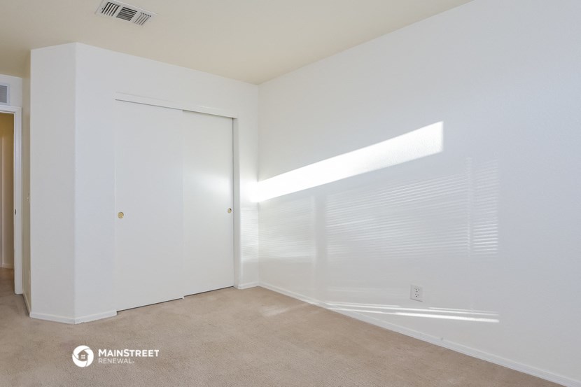 a bedroom with white walls and a large window with a white door