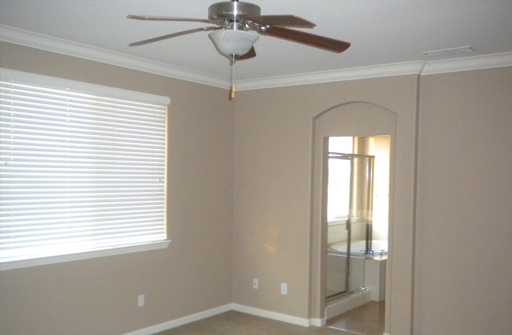 a bedroom with a ceiling fan and a mirror