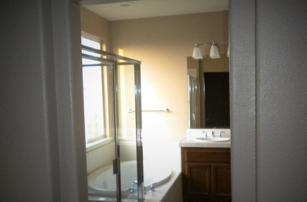a bathroom with a shower and a sink and a mirror