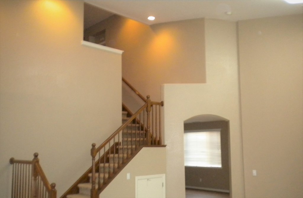 a view of a staircase in a house with lights on the wall