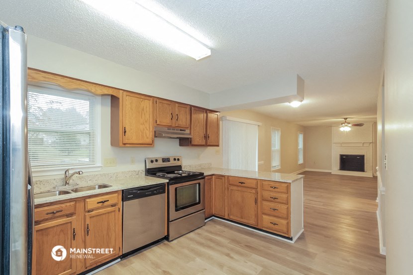 a kitchen with wooden cabinets and stainless steel appliances and a large window