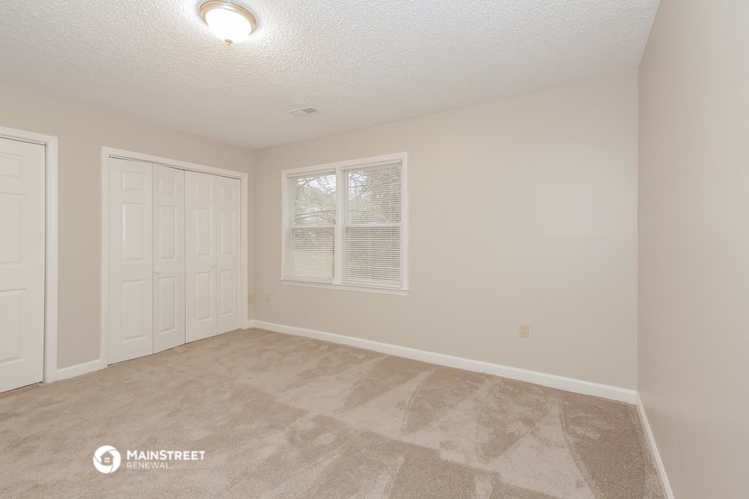 the spacious living room of a manufactured home with white doors and a window