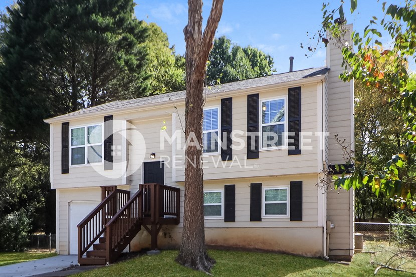a small house with a tree in front of it