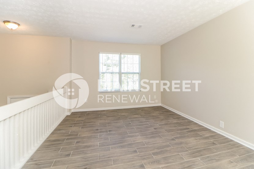 a white and gray living room with a wood floor and a window