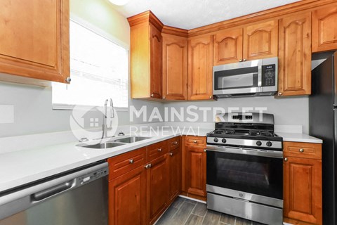 a kitchen with wood cabinets and stainless steel appliances