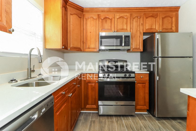 a kitchen with wooden cabinets and stainless steel appliances
