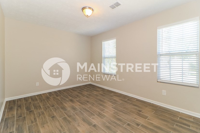 a living room with a hardwood floor and a window