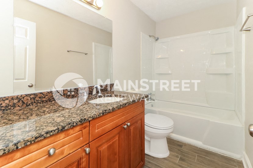 a bathroom with a shower and a sink and a toilet