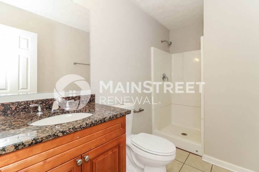 a bathroom with a toilet and a sink and a shower