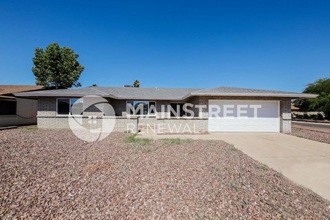 a small brick house with a garage and a driveway