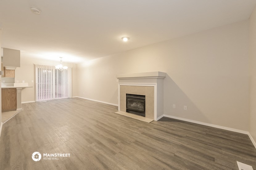 the living room with fireplace and wood flooring