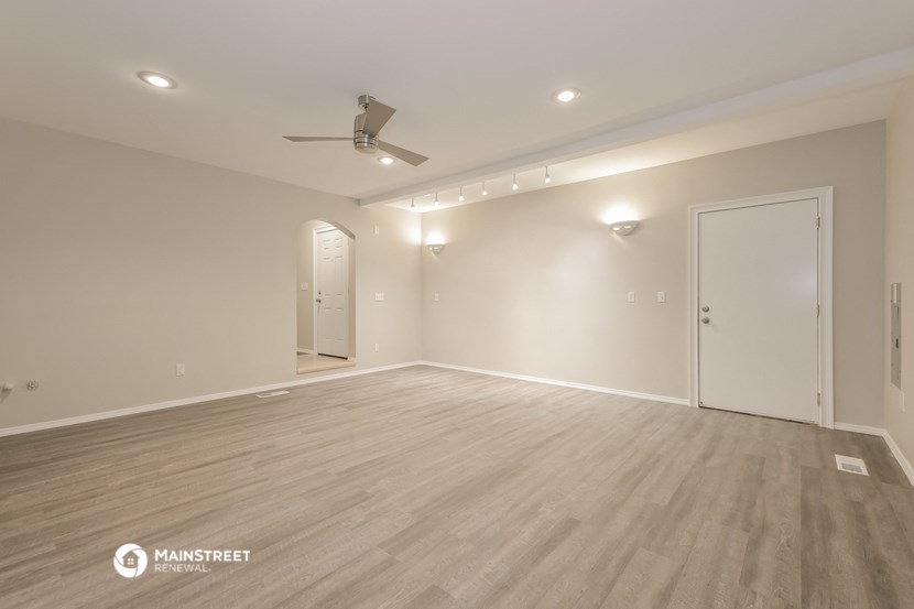 a living room with a wood floor and a ceiling fan