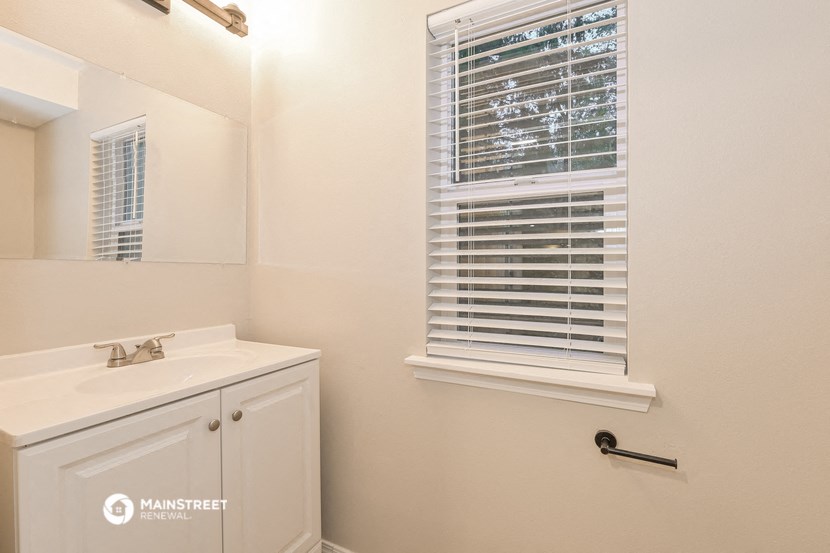 a bathroom with a sink and a mirror and a window