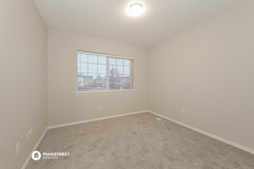 a spacious room with carpet and a window