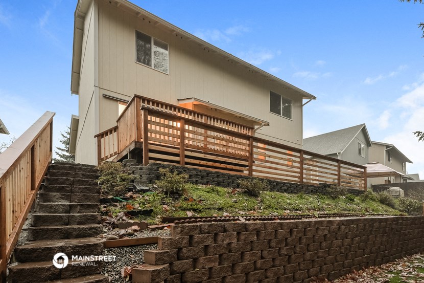 a house with a wooden fence and stairs in front of it