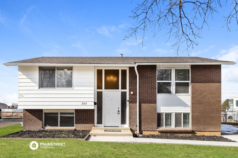 a white and brick house with a white front door