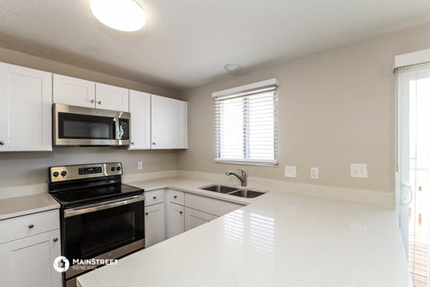 a kitchen with white cabinets and a white counter top