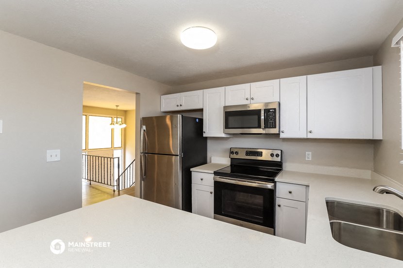 a kitchen with stainless steel appliances and white cabinets