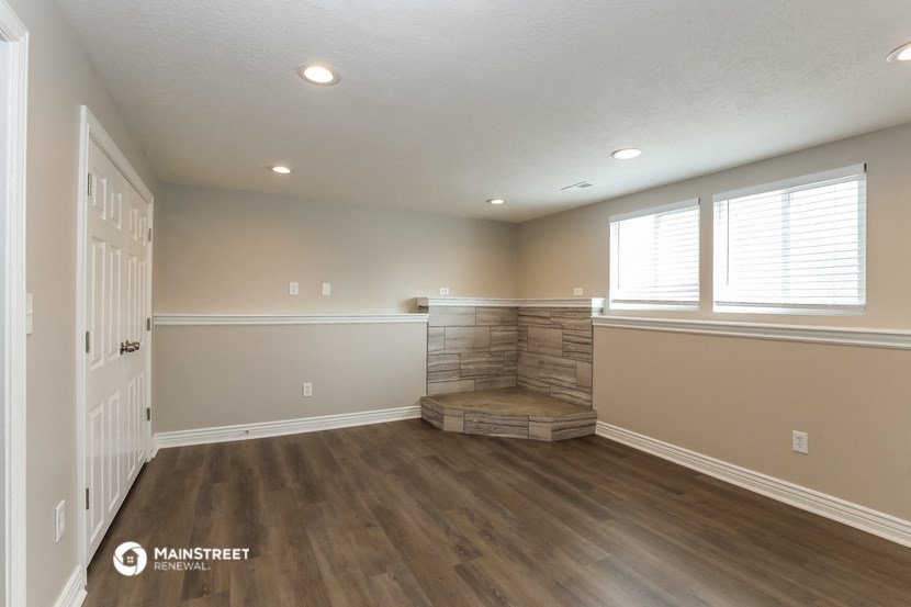 the living room with a fireplace and wood flooring