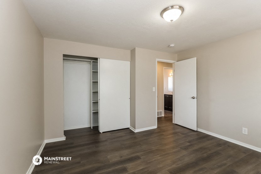 a renovated living room with white walls and wood flooring